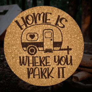 Round natural camper cork coaster featuring a detailed laser-engraved retro trailer and Home Is Where You Park It lettering