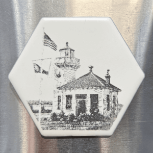 A white hexagon Mukilteo lighthouse ceramic magnet featuring a detailed black illustration of the historic Mukilteo Lighthouse and American flag