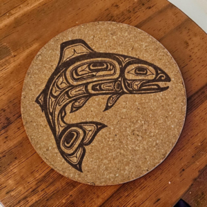 1. Product Description: Bring the wild, majestic spirit of the Pacific Northwest into your home with this salmon cork coaster. Featuring a detailed, Pacific Northwest Formline-style salmon artwork laser-etched directly onto natural tan cork, this coaster combines bold cultural artistry with dependable everyday functionality. The dark, crisp contrast of the engraved swimming salmon creates an eye-catching accent for your coffee table, office desk, or cabin counter. We crafted this coaster to look like a piece of art while giving your tabletop surfaces solid protection. Premium natural cork is lightweight, absorbent, and heat-resistant, keeping your wood and glass furniture safe from cold-drink condensation rings, hot coffee mugs, and accidental scuffs. It stays firmly in place without sliding, making it as reliable for your morning brew as it is when entertaining guests with cold drinks. Whether you are adding rustic cabin charm to your own living room or looking for a thoughtful, eco-friendly gift for anglers, wildlife lovers, and outdoors enthusiasts, this salmon cork coaster delivers the perfect blend of utility and regional design. Protect your furniture in style and grab yours today! 2. Focused Keyphrase: salmon cork coaster 3. Meta Description: Protect surfaces with our salmon cork coaster, featuring a detailed laser-engraved salmon design on absorbent cork. Order yours today! 4. Image Attributes: Image File Name: salmon-cork-coaster.jpg Alt Text: Round natural salmon cork coaster with a detailed laser-engraved Pacific Northwest style salmon design